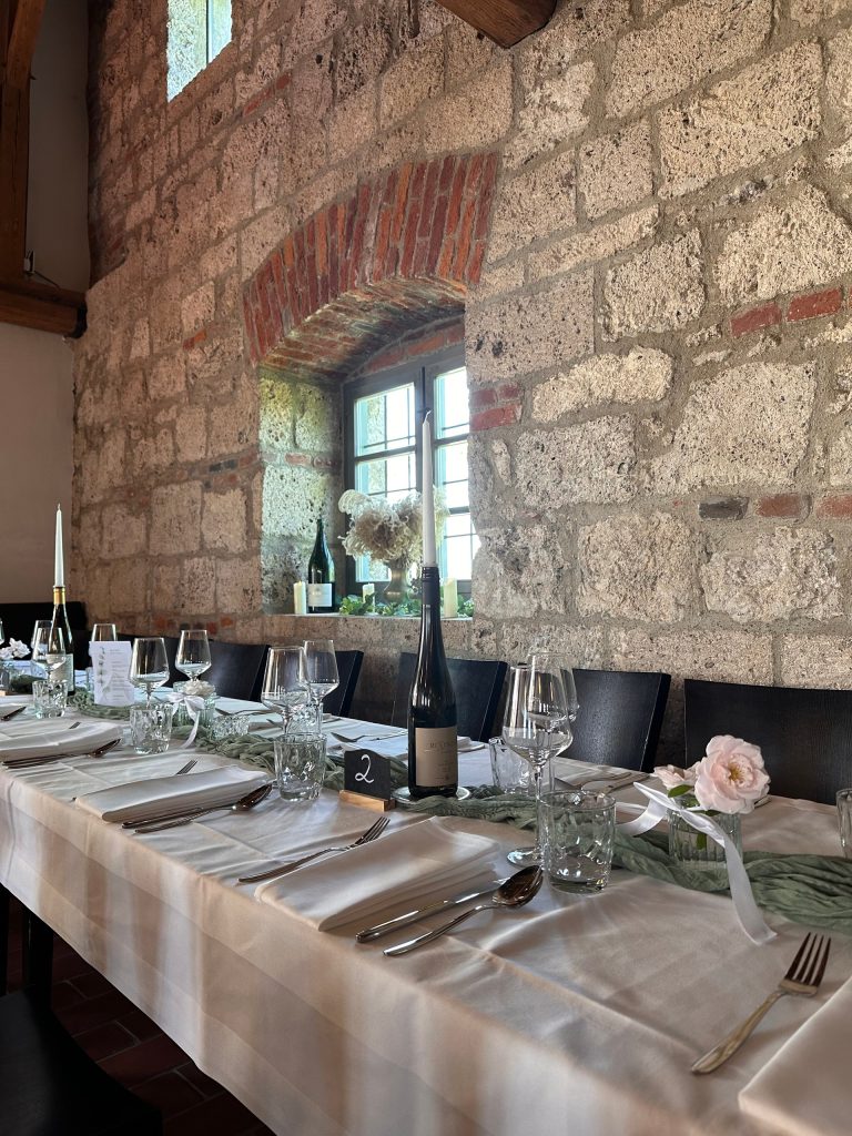 Lange, festlich gedeckte Tafel mit Kerzen im Burg Café